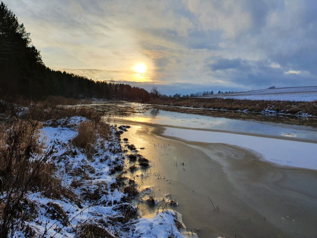 Talvinen Paimionjoki virtaa auringon laskiessa.