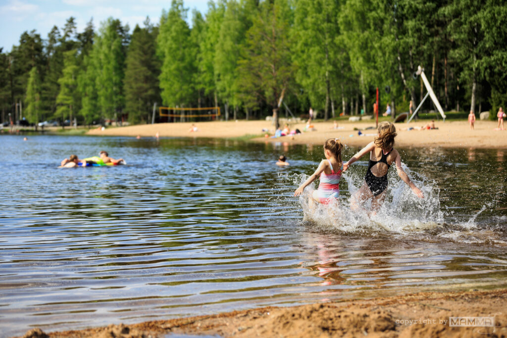 Ankkalammen maauimalassa on mukava uida. Kaksi tyttöä juoksee veteen.