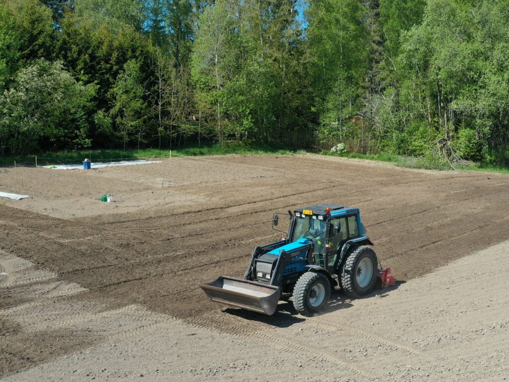 Traktori muokkaa maata viljelypalstoilla.