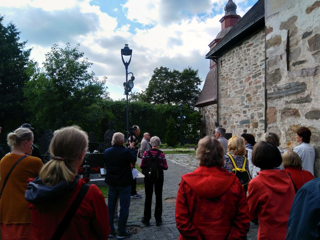 Opas ja yleisöä Pyhän Mikaelin kirkon vieressä.