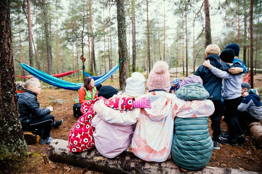 Opettajia ja oopilaita metsässä syksyisessä metsäkoulussa.