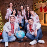 Ukrainalainen lauluyhtye Simnot - viisi naista ja kaksi miestä - kuvattuna takkatulen ja joulukuusen edessä.
