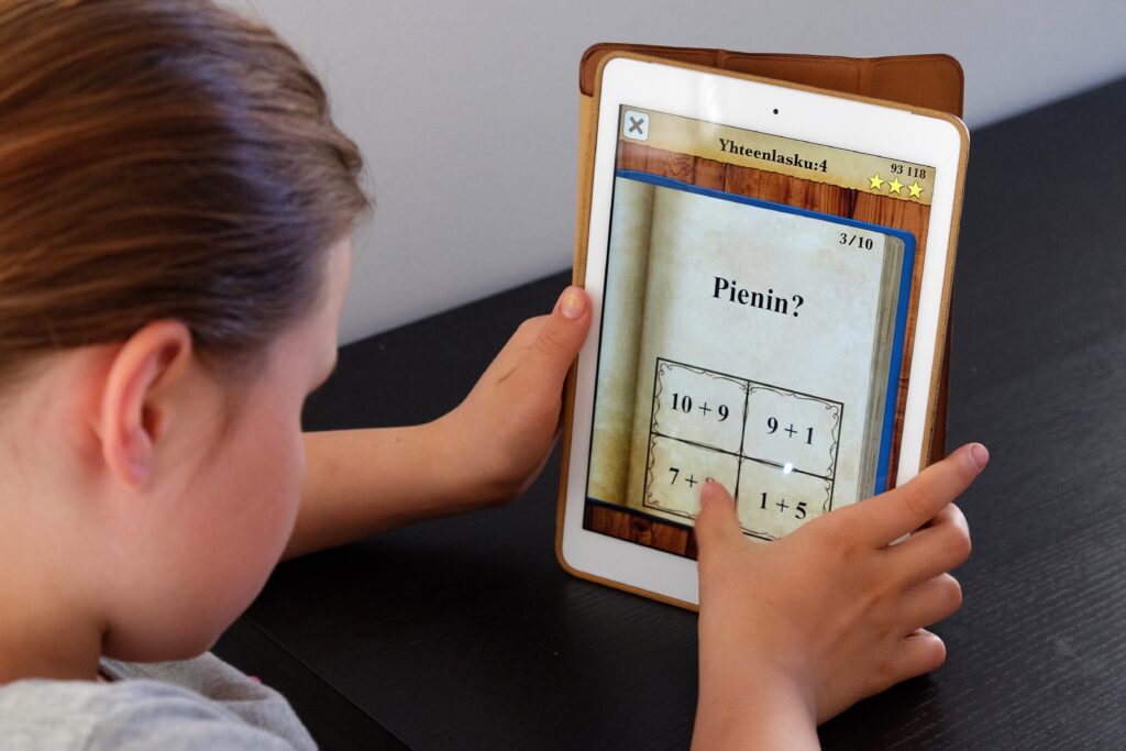 Koululainen tekee tehtävää tabletin avulla.