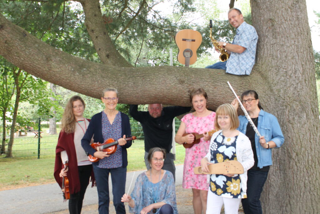 Paimion musiikkiopiston opettajia ryhmäkuvassa, joka on otettu ison puun äärellä.