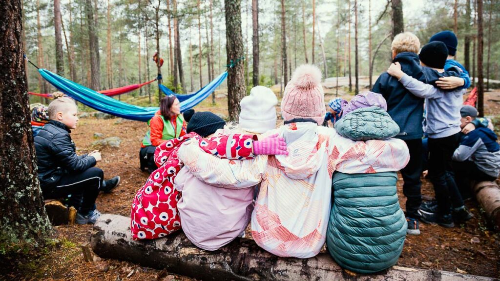 Children sitting in the wood.