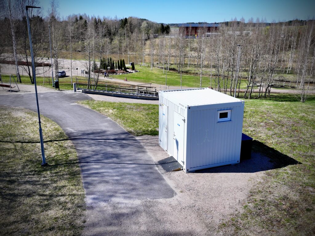 Jokipuiston WC ja taustalla puistoaluetta sekä kuntoportaat.