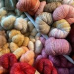 Runsaasti erivärisiä villalankakeriä.