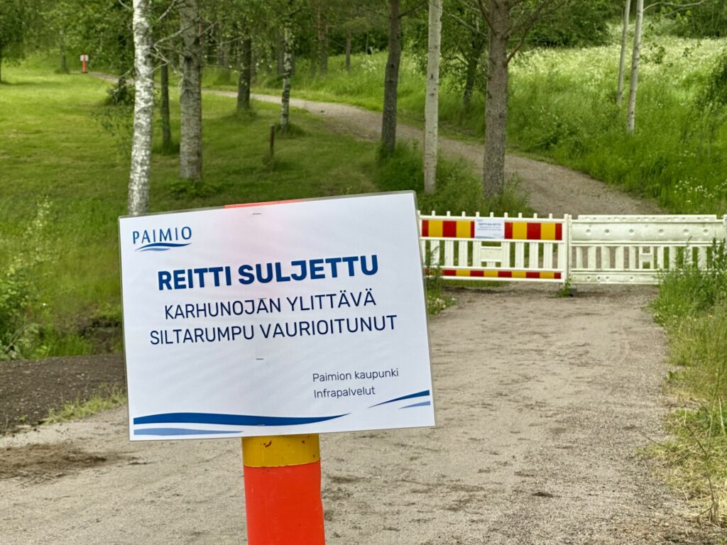 Näkymä kevyenliikenteenväylästä, jonka poikki on asetettu huomiovärein varustettu este. Lisäksi kyltti, jossa lukee Reitti suljettu.