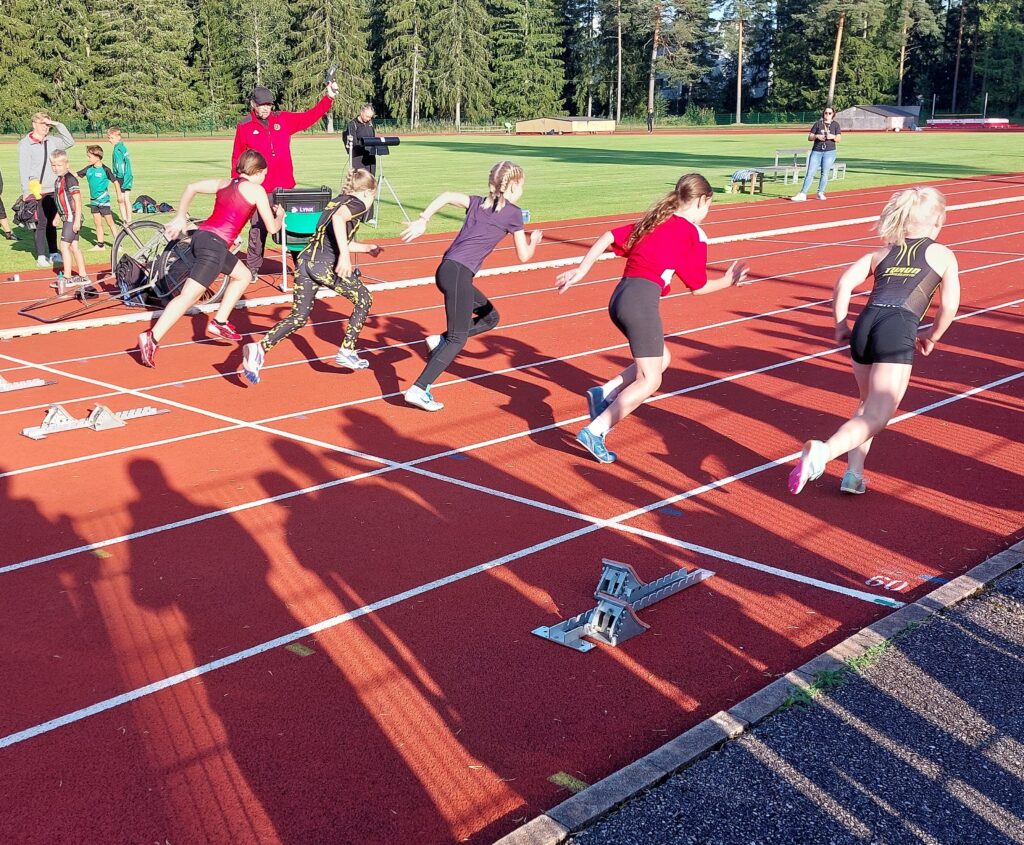 Juniorijuoksijoita lähtenyt juuri liikkeelle pikajuoksuun lähtötelineistä.