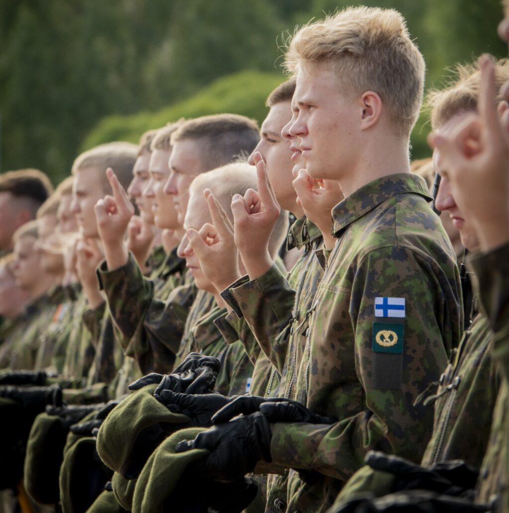 Alokkaita vannomassa sotilasvalaa sotilaspuvut yllään.