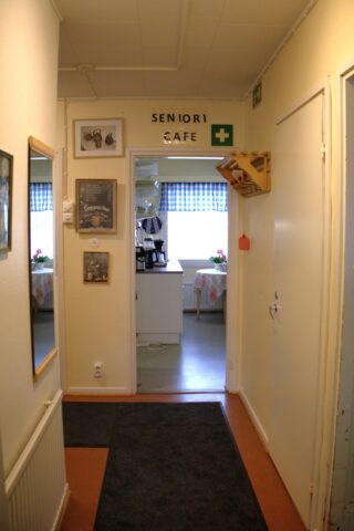 Näkymä sisään tullessa Hyvän Olon Pysäkille. Edessä keittiö, jonka yllä lukee Seniori Cafe