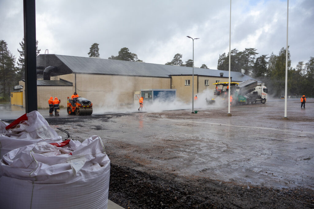 Sisäliikuntahallin ovelta kuvattu parkkipaikan asvaltointia. Taustalla Paimion jäähalli.
