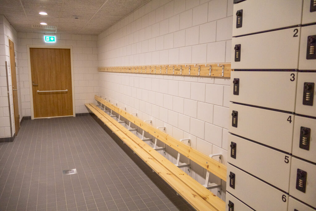 Pukuhuone, jossa näkyy lukittava lokerikot ja penkit ja naulakot.