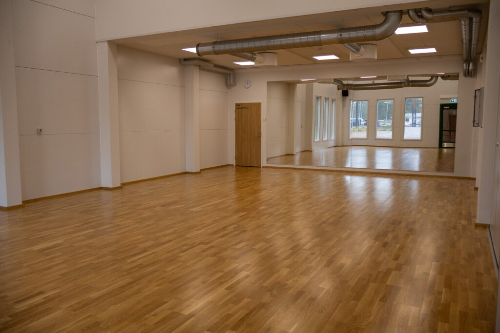 Sisäliikuntahallin monitoimisalit. Taustalla koko seinän levyiset peilit.