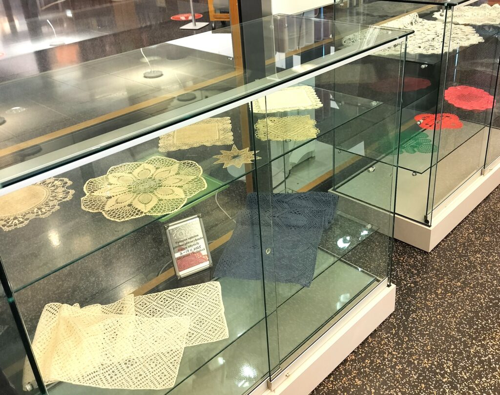 Pitsinnypläystöitä esillä kirjaston vitriinissä.