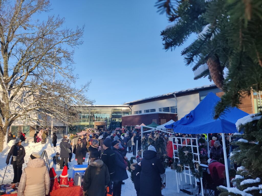 Ihmisvilinää markkinoilla talvisessa tunnelmassa.