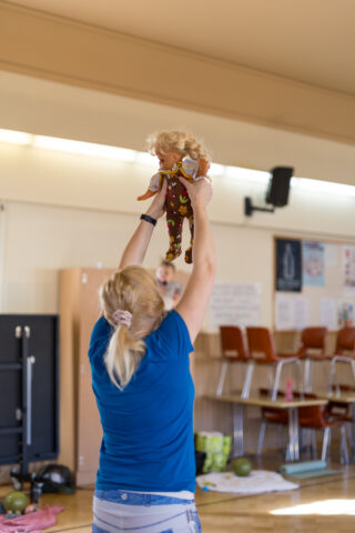 Nainen pitää nukkea sylissään esimerkiksi muille vauvajumpassa
