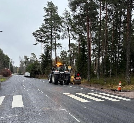 Juuri asvaltoidun tien lainassa työkoneita. Kuvassa näkyy myös maalattua suojatietä.