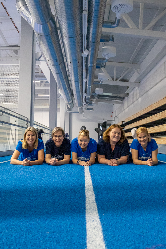 Opiston henkilökunta sisäliikuntahallin juoksuradalla