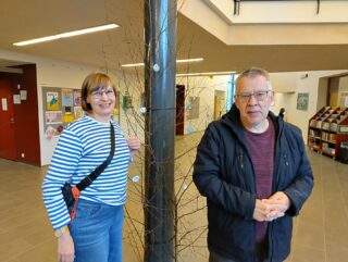 hyte-koordinaattori Matleena sekä Juhani seisovat heijastinpuun edessä ja katsovat kameraan.