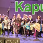 Runsaasti naisia esiintymässä lavalla. Yläkulmassa teksti Kapua.