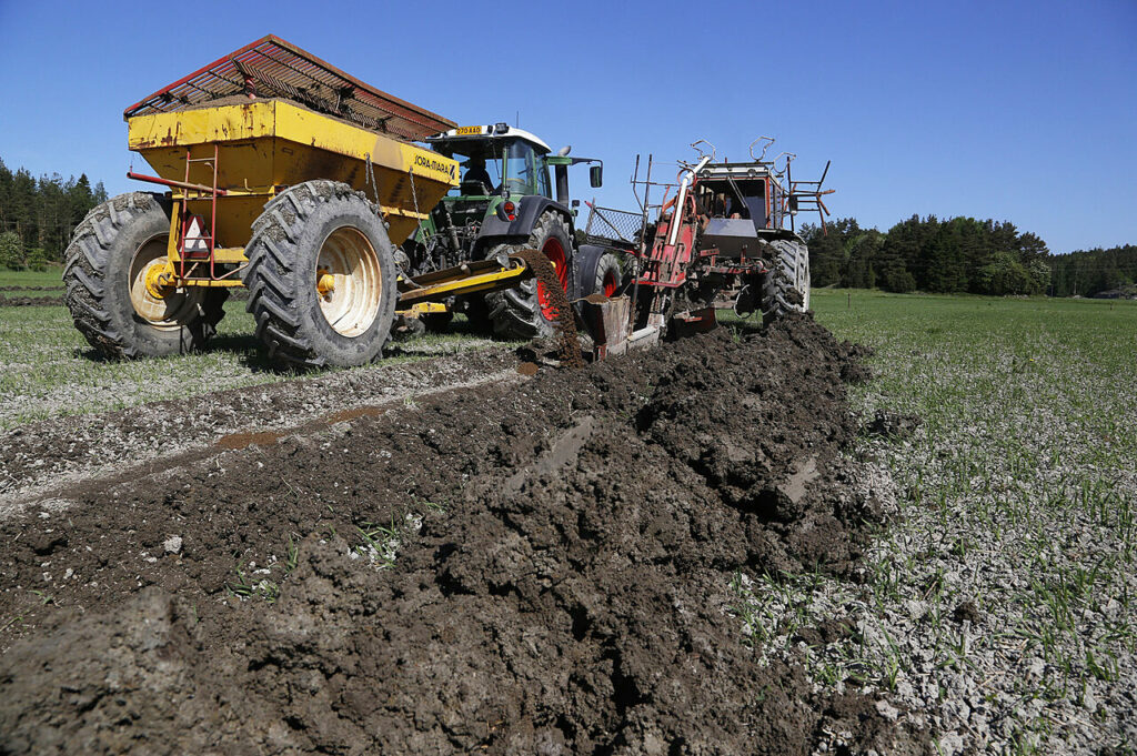 Kuvassa näkyy savinen pelto ja kaksi traktoria maanmuokkaustehtävissä. ProAgrian kuva.