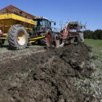 Kuvassa näkyy savinen pelto ja kaksi traktoria maanmuokkaustehtävissä. ProAgrian kuva.