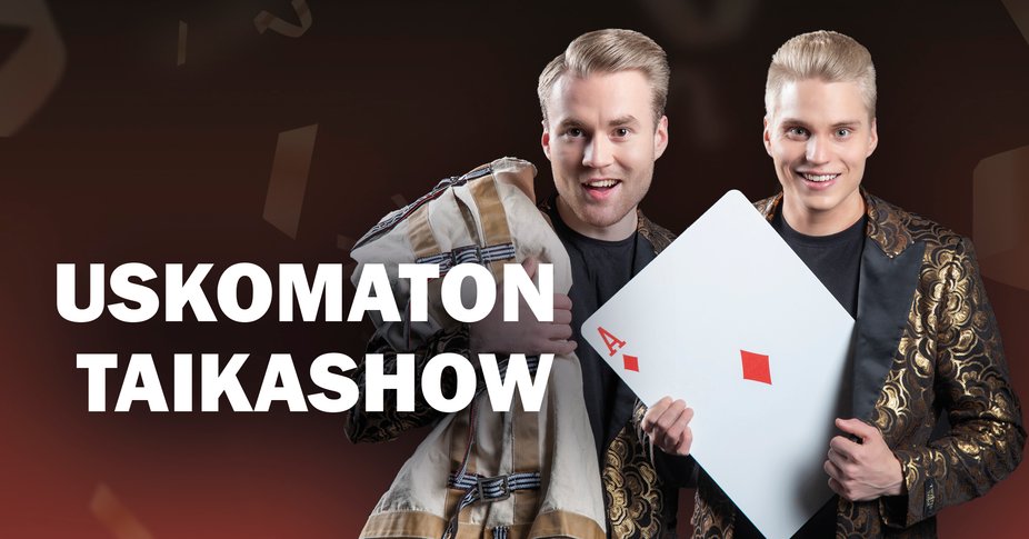 Kaksi nuorta miestä esiintymisvaatteissa. Toisella miehellä on sylissään erittäin iso pelikortti.