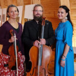 Kaksi naista ja mies seisomassa.. Toisella naisella kädessä viulu ja miehellä sello.