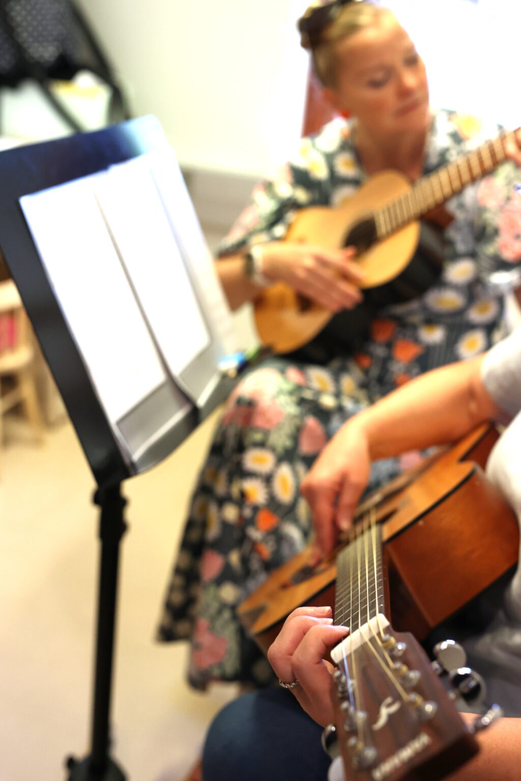 Nainen opettaa kitaransoittoa