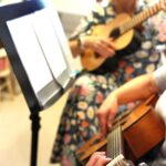 Nainen opettaa kitaransoittoa