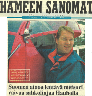 Oikealla mies, vasemmalla osa helikopterin hytistä. Ylhäällä ja alhaalla tekstiä.