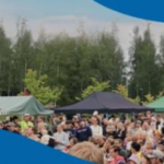Kesäisessä tapahtumassa paljon yleisöä ulkoalueella. Lisäksi näkyy esittelytelttojen kattoja.