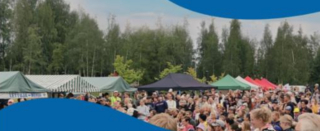 Kesäisessä tapahtumassa paljon yleisöä ulkoalueella. Lisäksi näkyy esittelytelttojen kattoja.