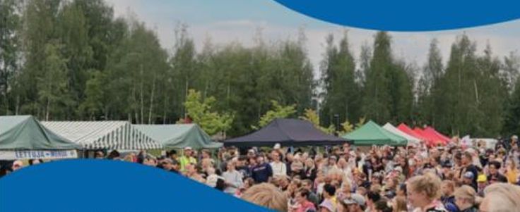 Kesäisessä tapahtumassa paljon yleisöä ulkoalueella. Lisäksi näkyy esittelytelttojen kattoja.