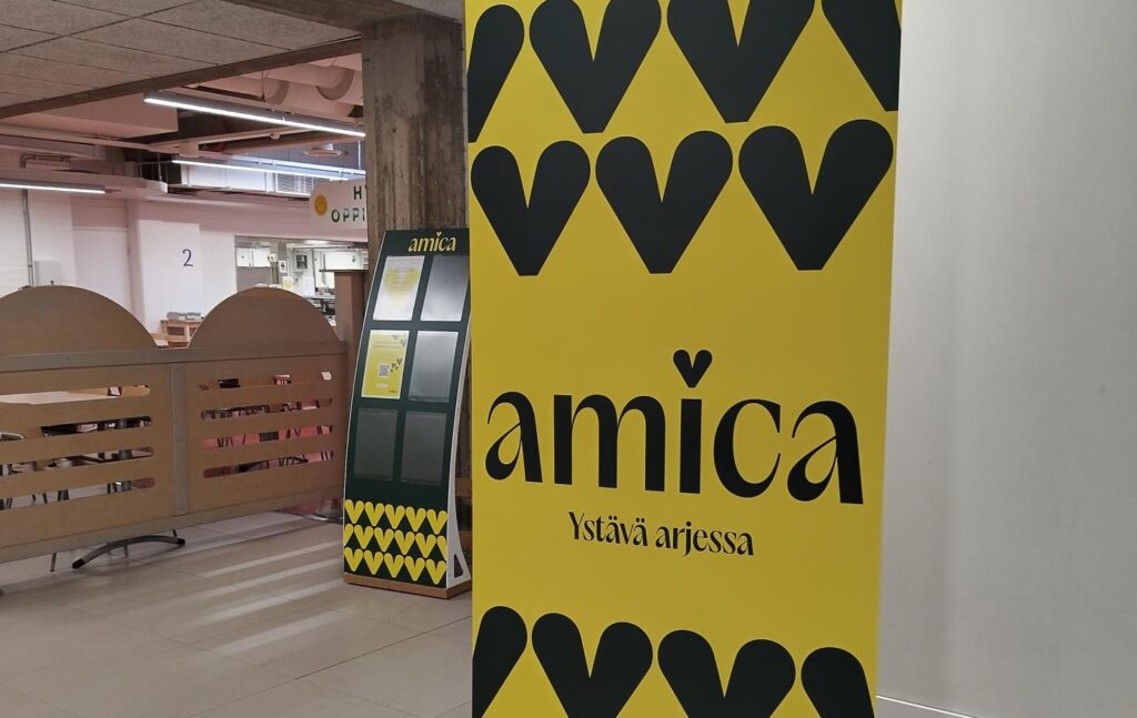 Taustalla näkyy ruokasali ja etualalla Amican tunnuksin varustettu roll up.