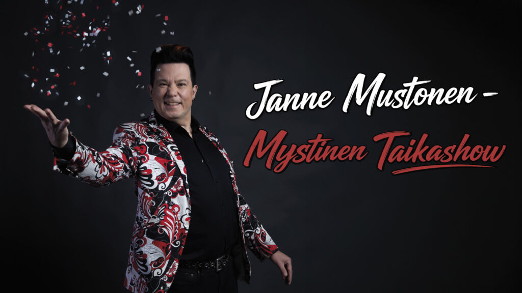 Tumman taustan edessä monivärisessä puvuntakissa oleva tummatukkainen mies.