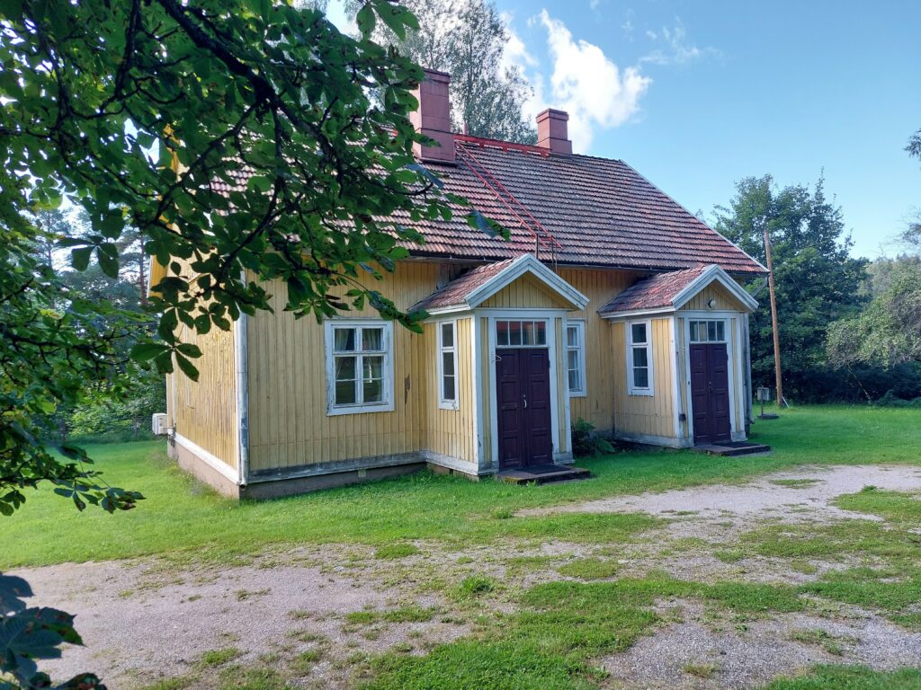 Keltainen, puolitoistakerroksinen puutalo, jossa on kaksi sisäänkäyntiä.