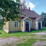 Keltainen, puolitoistakerroksinen puutalo, jossa on kaksi sisäänkäyntiä.