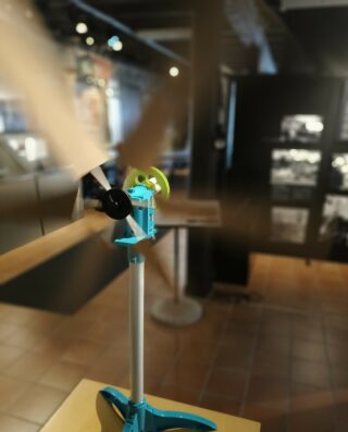 Pöydän päällä olevan tuulimyllyn pienoismallin siivet pyörivät voimmakkasti.