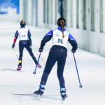 Kaksi nuorta hiihtäjää hiihtää numerolaput päällään hiihtotunnelissa.