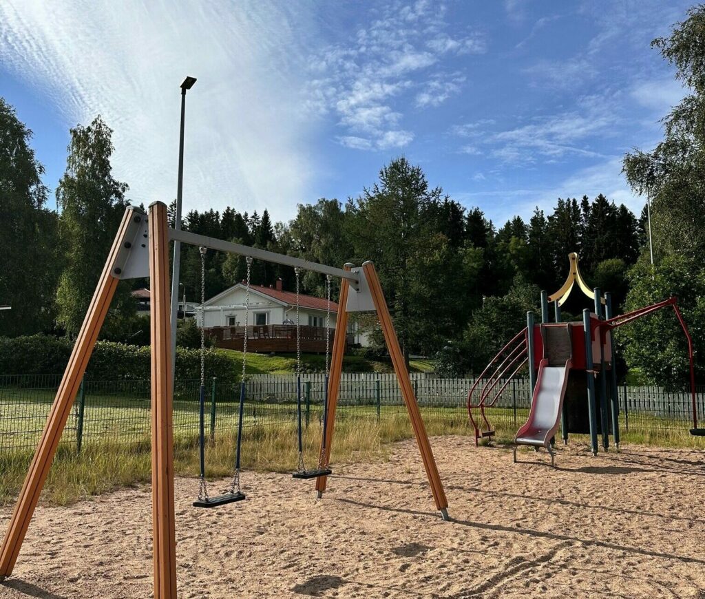 Peltolan leikkipaikka, etualalla keinut, taaempana kiipeilyteline.
